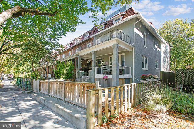 a view of a house with a yard and large tree