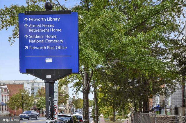 a view of a street with a bench and trees