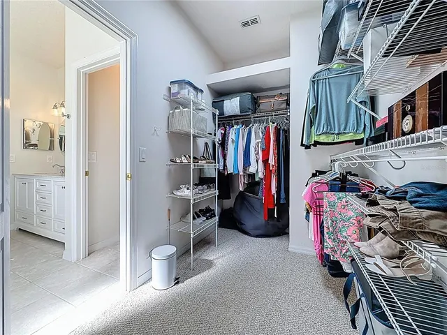 a bedroom with a large bed and a flat tv screen on dresser