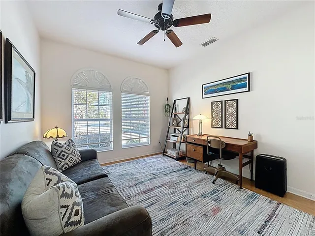 a living room with furniture a large window and a flat screen tv