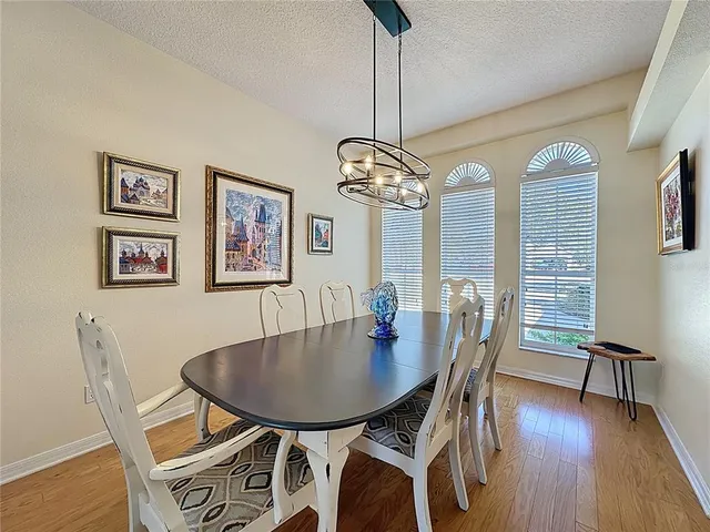 a large kitchen with stainless steel appliances granite countertop a stove top oven a sink dishwasher a dining table and chairs with wooden floor