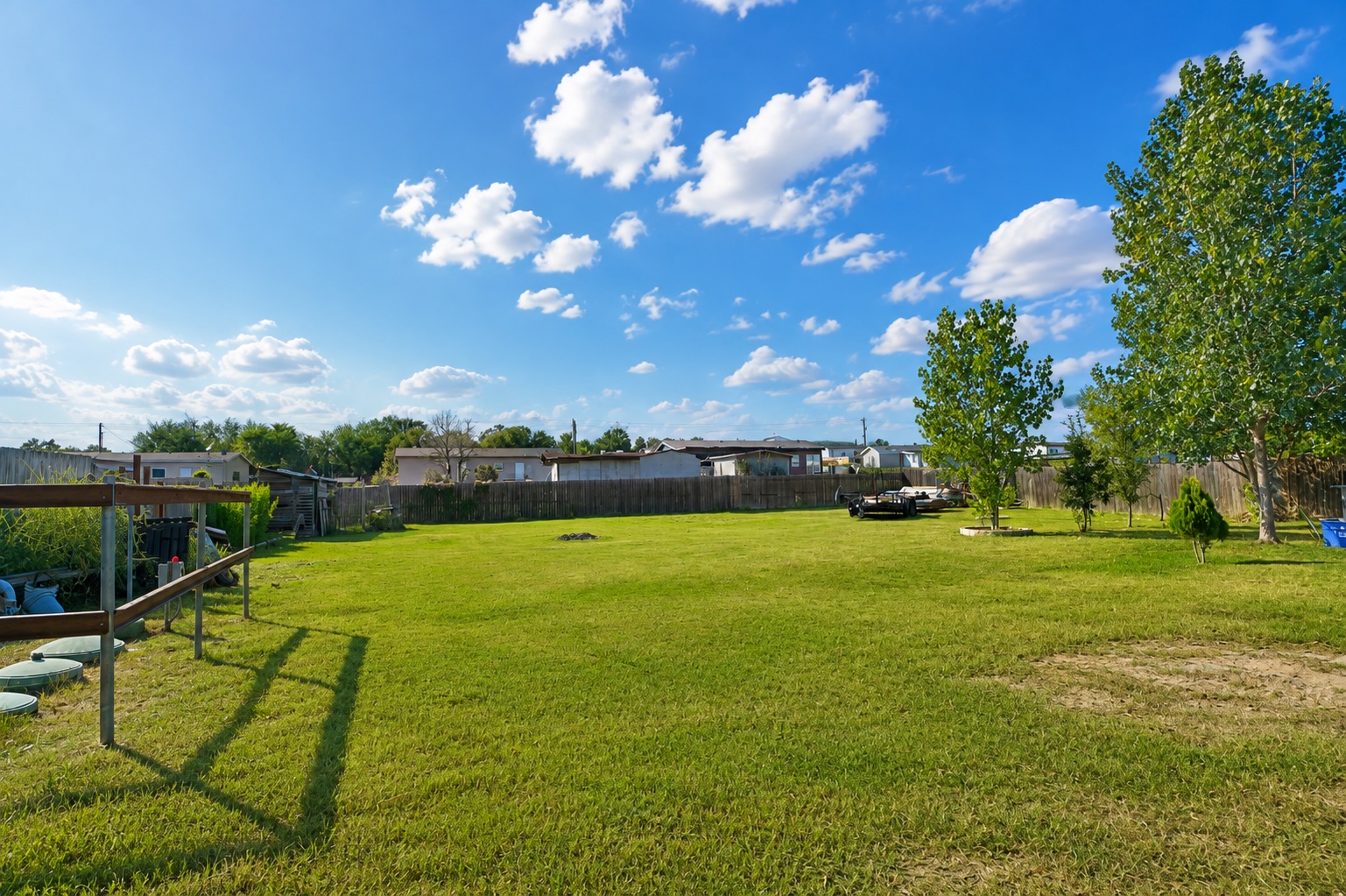 158 Buena Fortuna Road Elgin, TX 78621 - Photo 38 of 40 A spacious, verdant yard, fully fenced, offers ample room for outdoor activities under a bright, open sky.