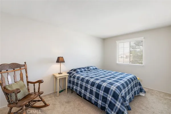 a bedroom with a bed a chair and a window