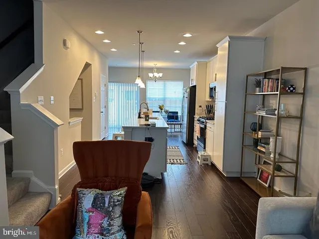 a view of kitchen with stainless steel appliances refrigerator stove and wooden floor