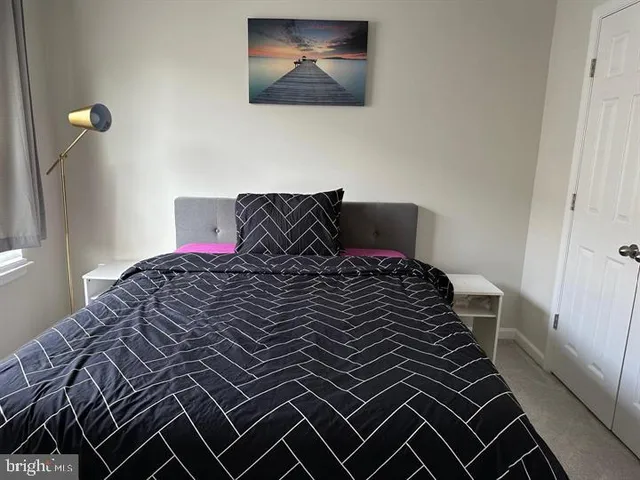 a bedroom with a bed and a painting on the wall