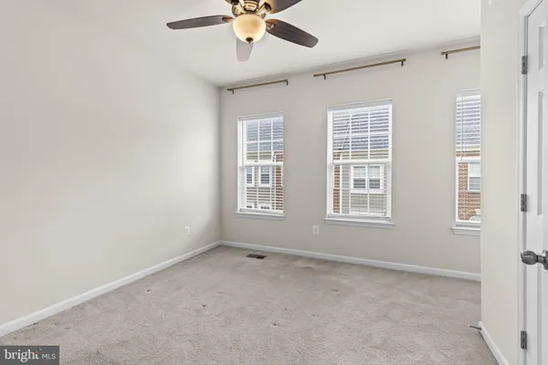 an empty room with a window and a fan