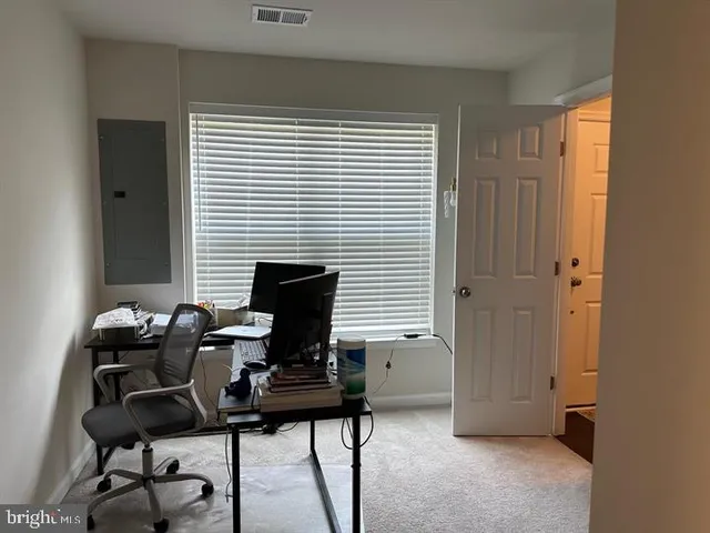 a view of a workspace with furniture and a window