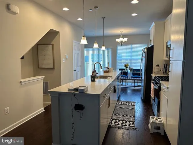 a kitchen with counter top space a sink a refrigerator and cabinets