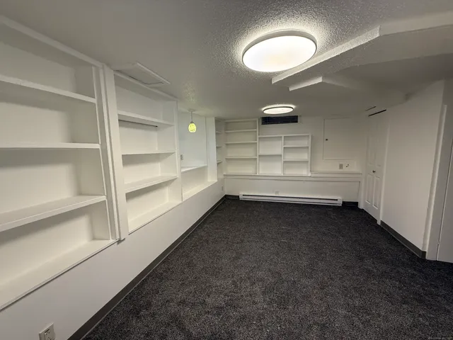 an empty room with cabinet and windows