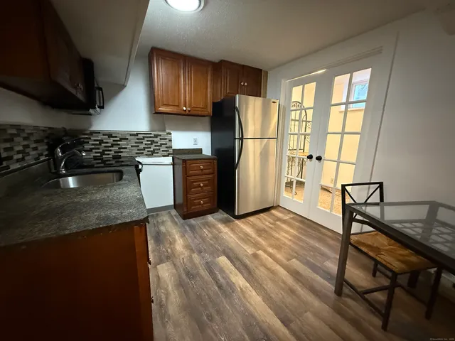 a kitchen with granite countertop wooden floors and stainless steel appliances