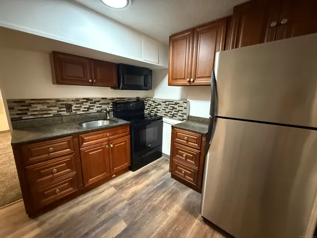 a kitchen with stainless steel appliances granite countertop a refrigerator stove and sink