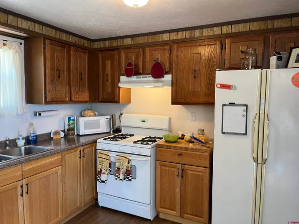 a kitchen with stainless steel appliances a refrigerator a stove and wooden cabinets