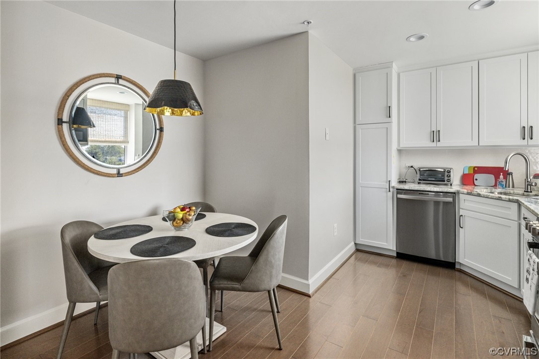 413 Stuart Circle, Unit U5E Richmond, VA 23220 - Photo 5 of 29 a kitchen with a table chairs a stove a microwave and cabinets