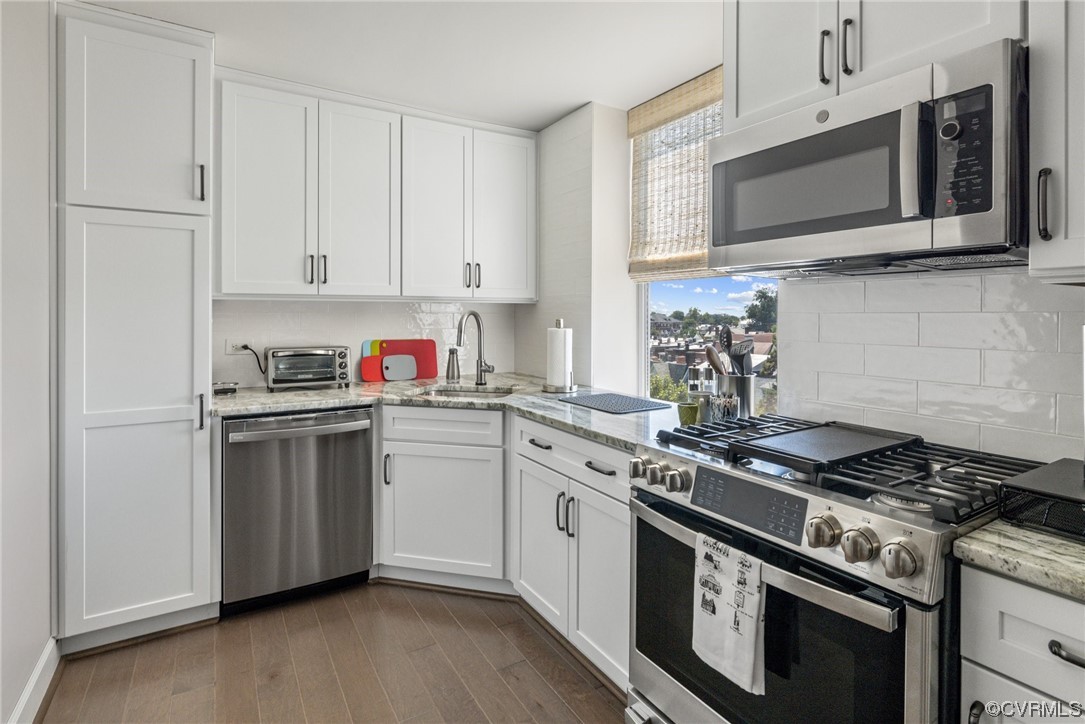 413 Stuart Circle, Unit U5E Richmond, VA 23220 - Photo 6 of 29 a kitchen with stainless steel appliances granite countertop a stove a microwave and cabinets