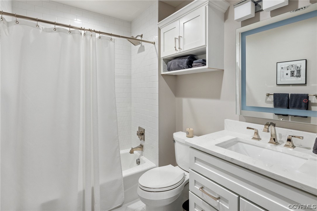 413 Stuart Circle, Unit U5E Richmond, VA 23220 - Photo 8 of 29 a bathroom with a granite countertop sink a toilet and a mirror