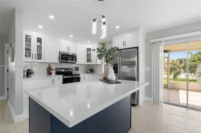 a kitchen with kitchen island a sink stainless steel appliances and counter space