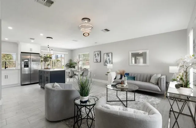 a living room with furniture and a dining table with kitchen view