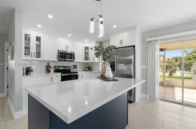 a kitchen with kitchen island a sink stainless steel appliances and counter space