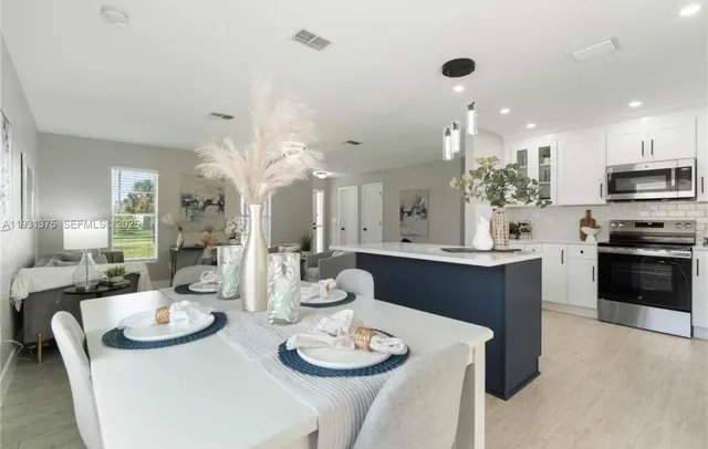 a kitchen with stainless steel appliances kitchen island granite countertop a sink and cabinets