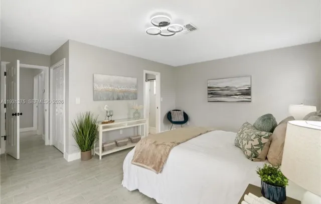 a bedroom with a large bed and a chandelier