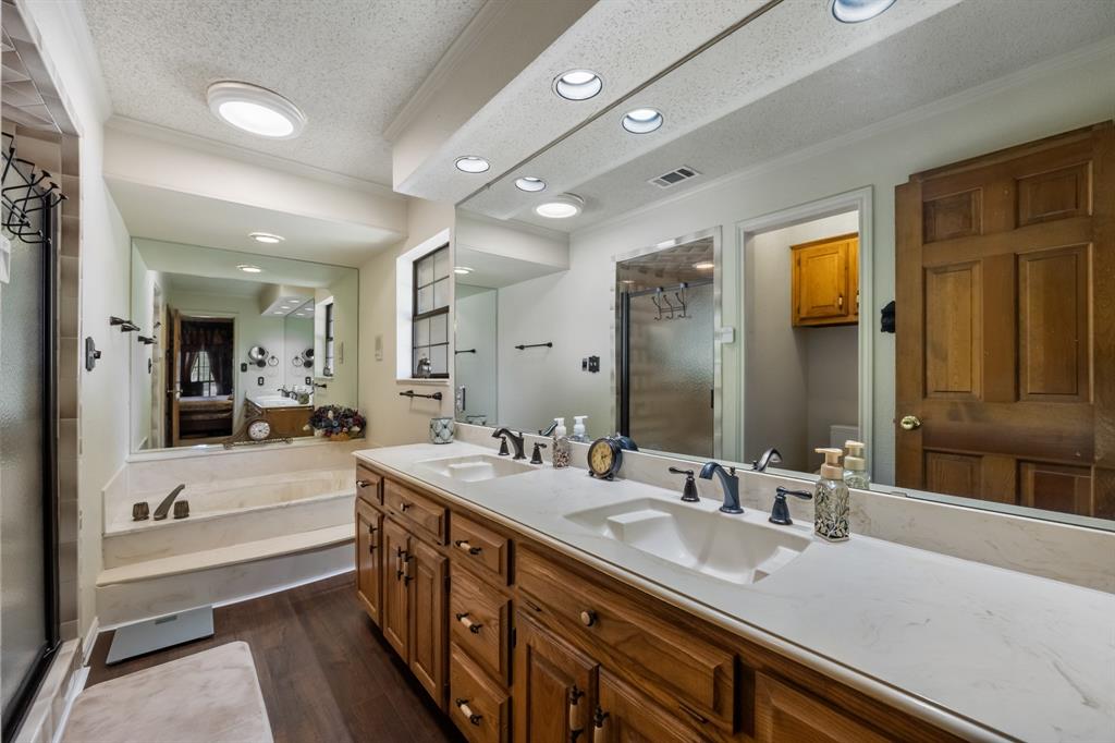 403 Riva Ridge Wylie, TX 75098 - Photo 15 of 32 Dual vanity with integrated sinks, recessed lighting, wood-finish flooring, full-width mirror, and a built-in tub