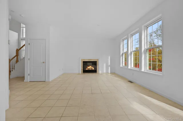 a view of an empty room with a fireplace and a window