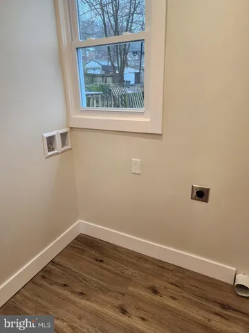 a view of a small space with wooden floor and a window