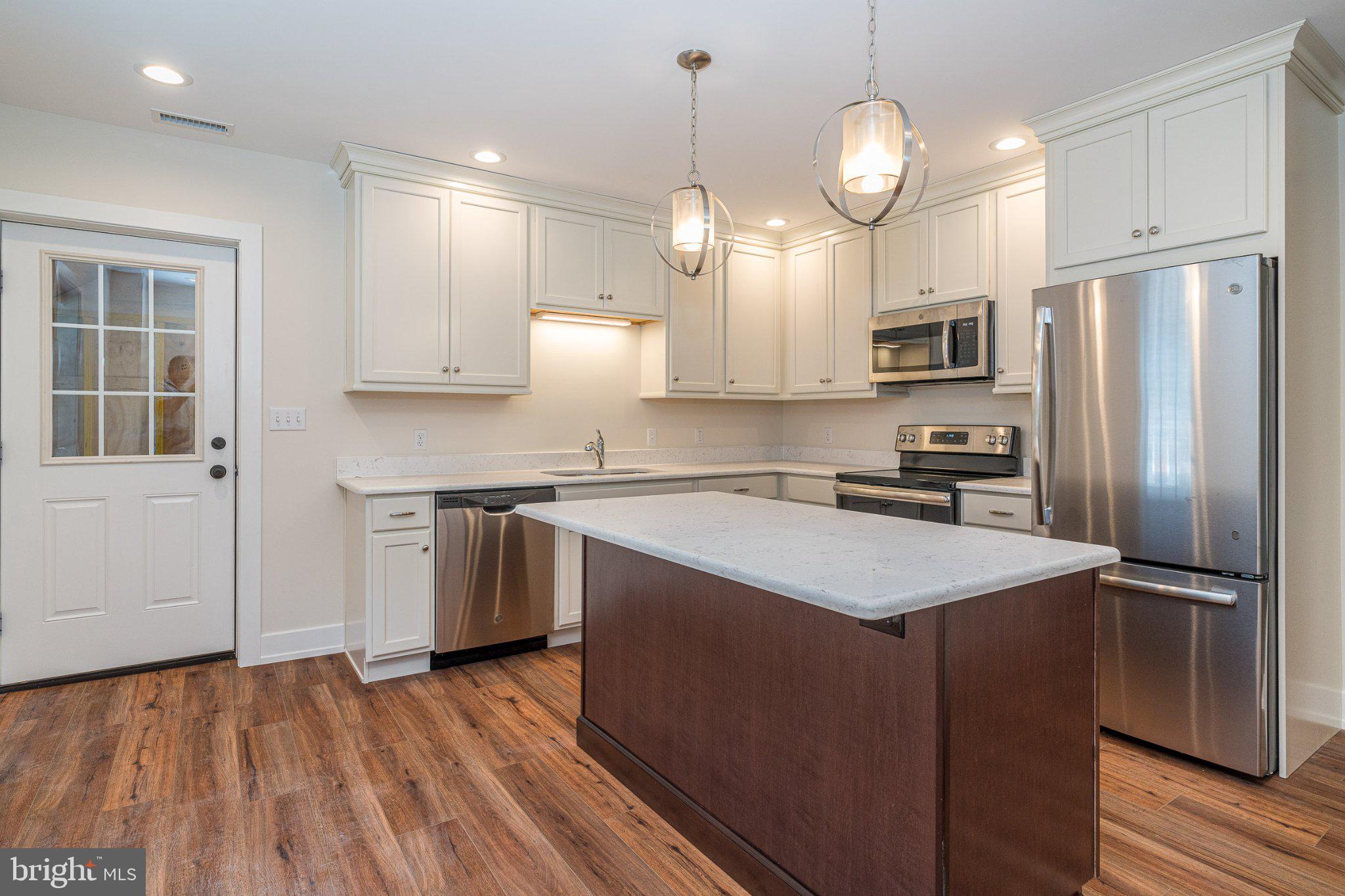 229 North High Street, Unit 3 West Chester, PA 19380 - Photo 1 of 16 a kitchen with kitchen island white cabinets and stainless steel appliances
