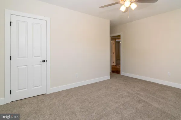 an empty room with a chandelier fan