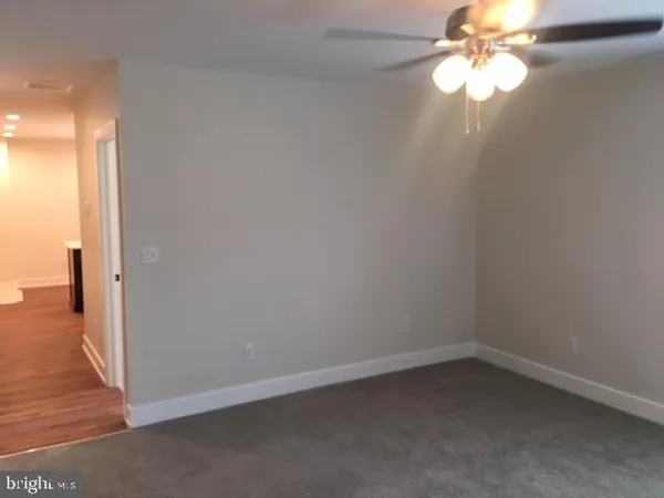 en empty room with wooden floor fan and window