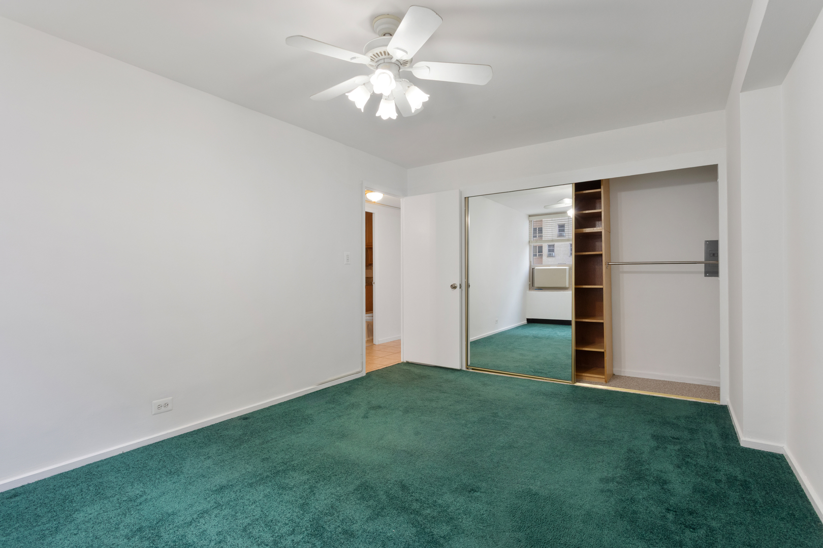 3950 North Lake Shore Drive, Unit 1006B Chicago, IL 60613 - Photo 9 of 12 an empty room with closet and a ceiling fan