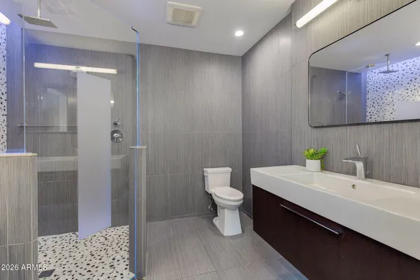 a bathroom with a sink a shower a mirror and a bathtub