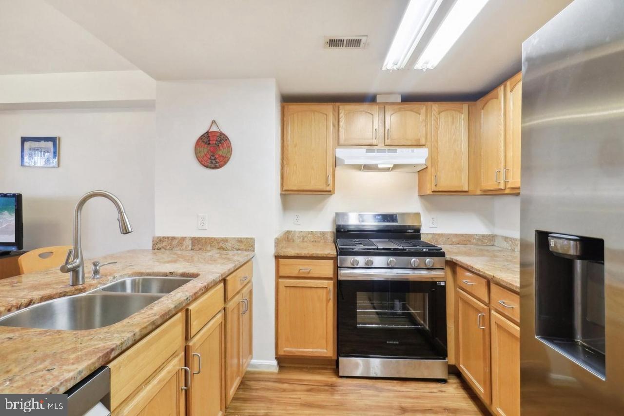 7981 Eastern Avenue Northwest, Unit 211 Silver Spring, MD 20910 - Photo 32 of 50 a kitchen with granite countertop a stove and a sink