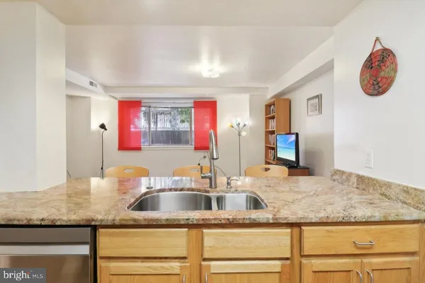 a open kitchen with white cabinets and stainless steel appliances