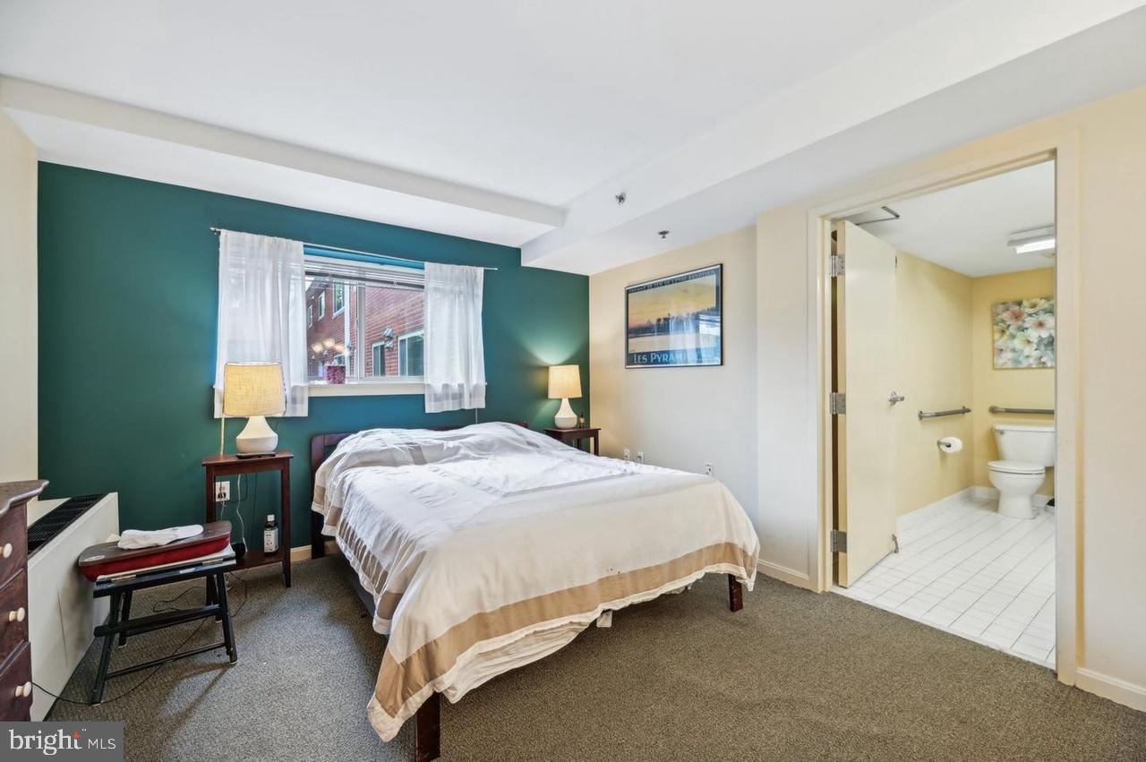 7981 Eastern Avenue Northwest, Unit 211 Silver Spring, MD 20910 - Photo 49 of 50 a bed room with a bed and a chair