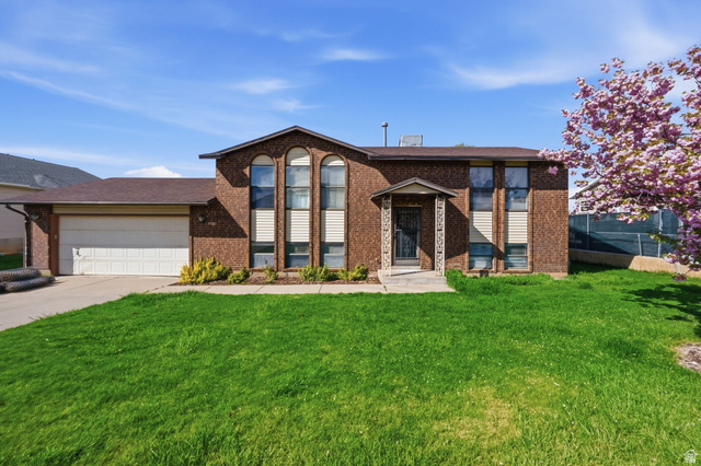3080 West 4600th Street South Roy, UT 84067 - Photo 1 of 1 Split foyer home with a garage, brick siding, concrete driveway, and a shingled roof