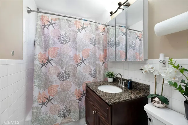a bathroom with a granite countertop sink a mirror and shower