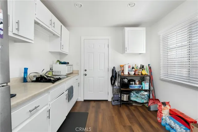 a kitchen with a sink cabinets and wooden floor