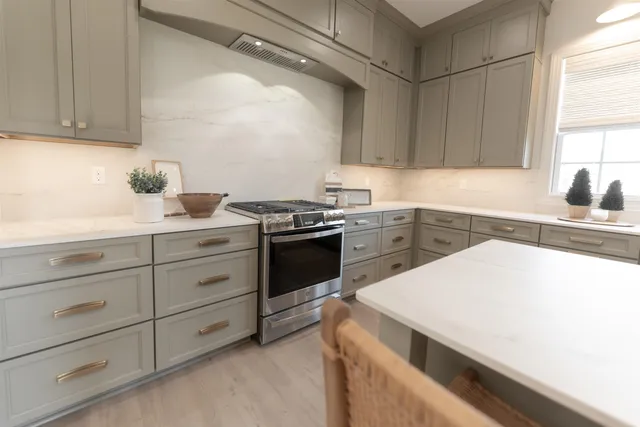 a large white kitchen with a refrigerator a stove and a cabinets
