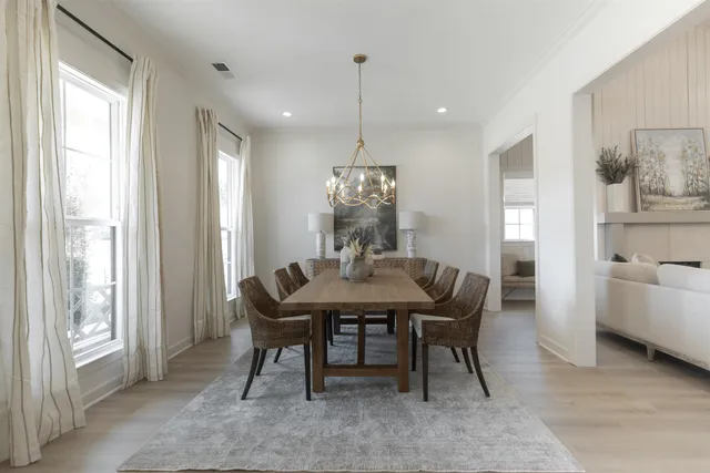 a dining room with furniture a chandelier and wooden floor