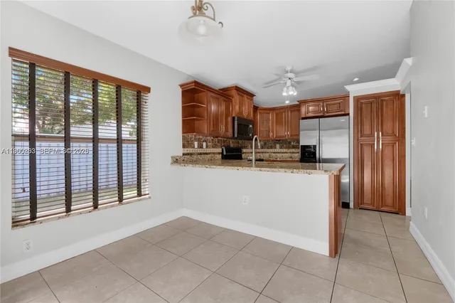 a view of kitchen with stainless steel appliances granite countertop a refrigerator and a sink