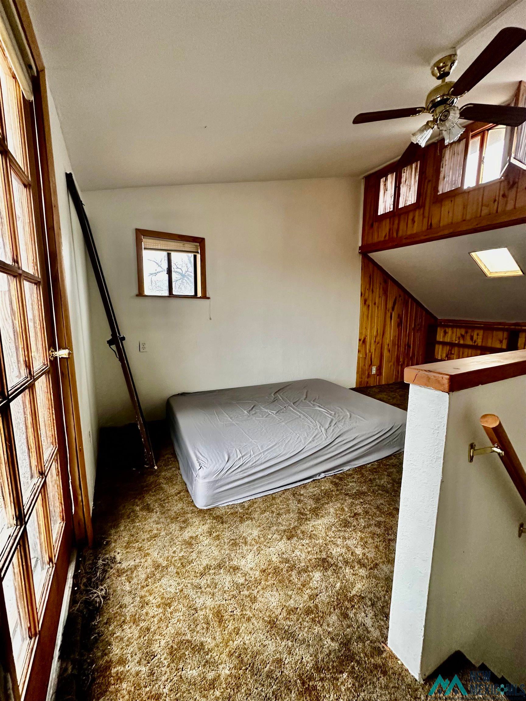 31 Bill Knight Gap Road Luna, NM 87824 - Photo 19 of 41 Unfurnished bedroom featuring a ceiling fan, carpet floors, and wooden walls