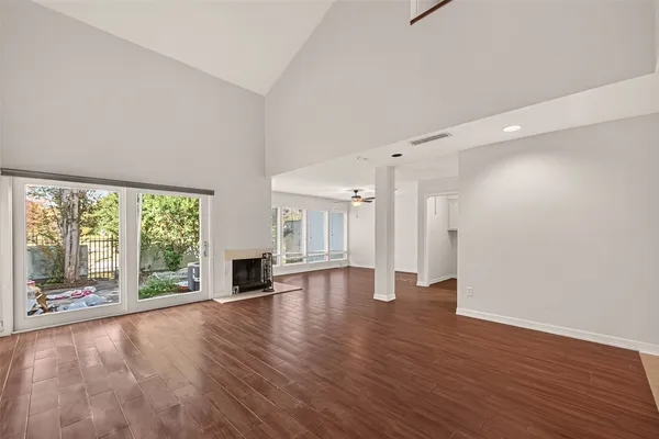 a view of empty room with wooden floor and fireplace