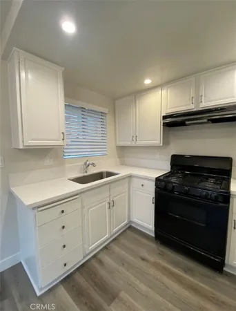 a kitchen with a sink stove and cabinets