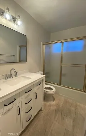 a bathroom with a granite countertop sink toilet and shower