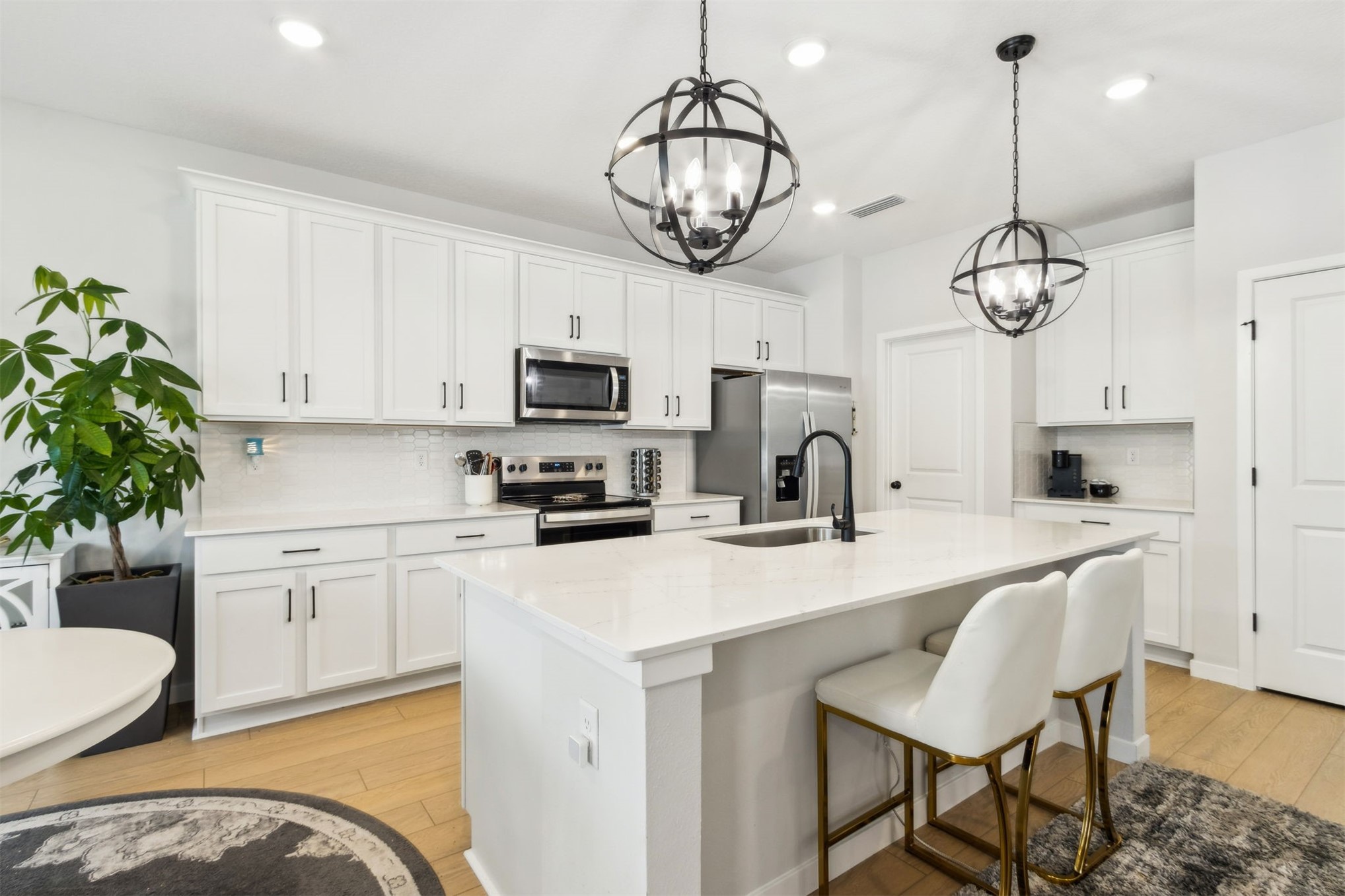 96277 Broadmoore Road Fernandina Beach, FL 32034 - Photo 6 of 26 a kitchen with stainless steel appliances a dining table chairs a microwave a refrigerator and a sink