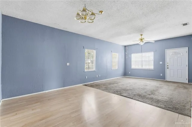 an empty room with fan and ceiling fan
