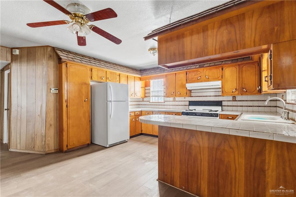 101 Ash Street Donna, TX 78537 - Photo 5 of 14 a kitchen with stainless steel appliances granite countertop a refrigerator a sink and dishwasher