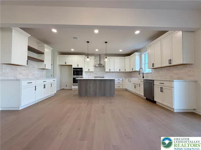 a large kitchen with stainless steel appliances granite countertop a stove a sink dishwasher and a refrigerator