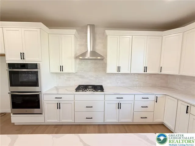a kitchen with white cabinets and appliances